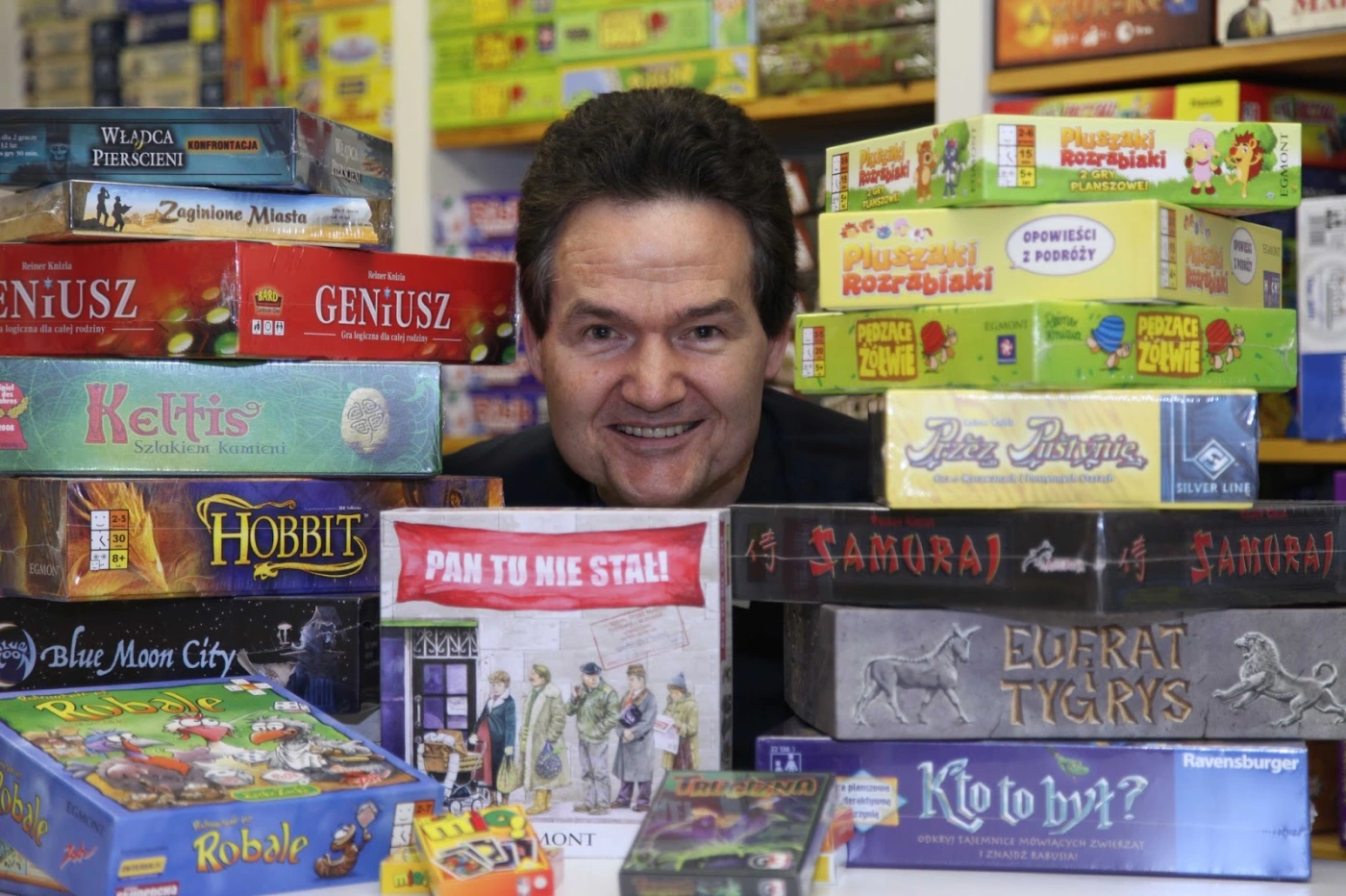 Reiner Knizia with a collection of his most successful board games, including Ra and Tigris & Euphrates.