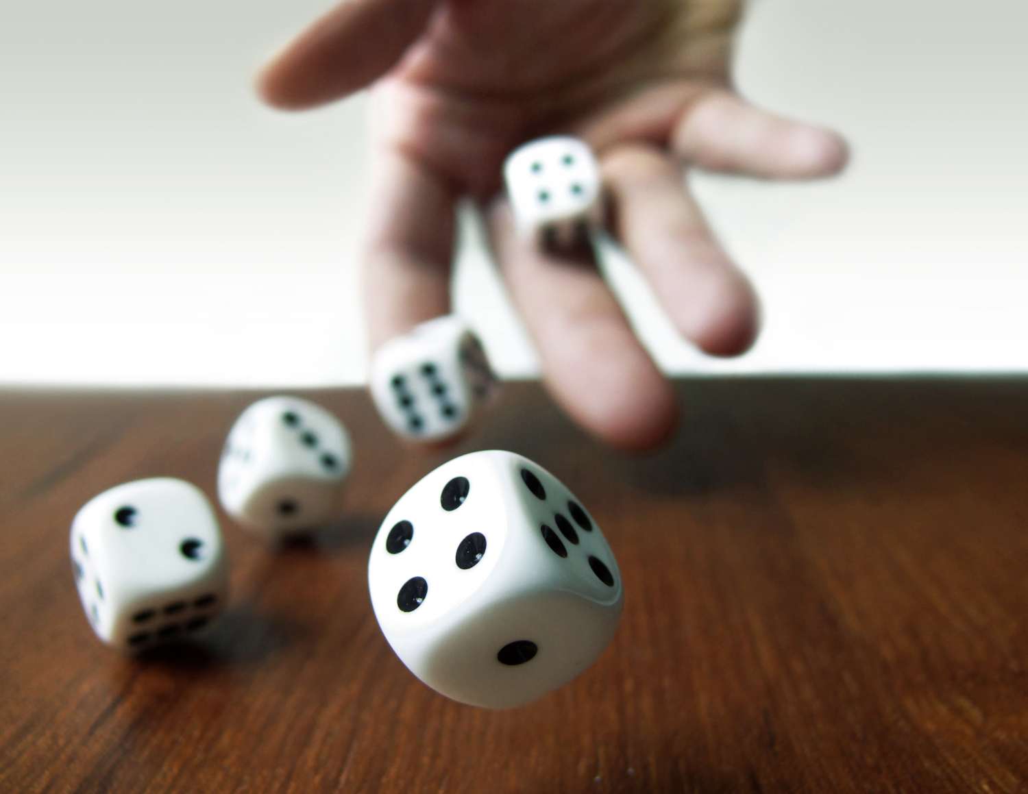 Hand rolling dices to wooden board